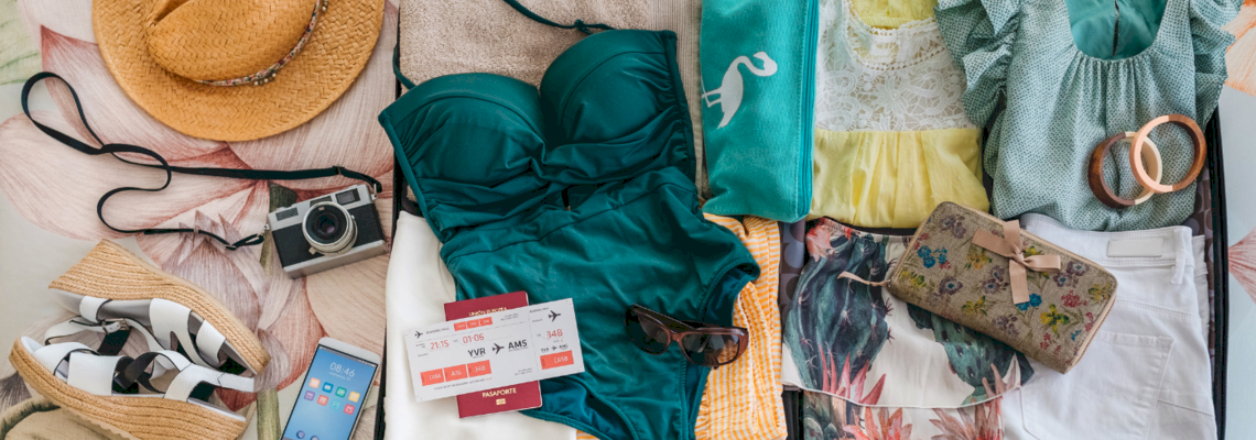 Geöffneter und gepackter Koffer mit Bekleidung und Accessoires für Frauen